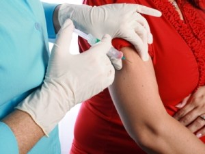 arm of pregnant woman getting flu vaccine