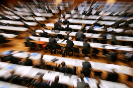 Blur of people at tables in lecture hall