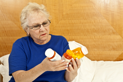 Older woman examines pill bottles