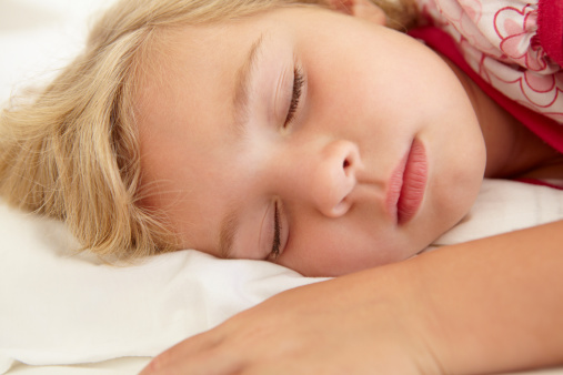 Young Girl Sleeping On Bed In Bedroom