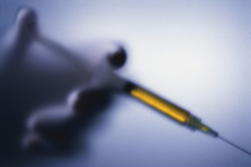 Close-up of a person holding a syringe