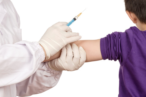 Holding child's arm while preparing to give an injection