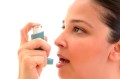 Young woman using an asthma inhaler