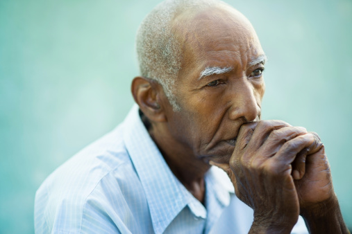 Elderly senior man resting his head on his hands
