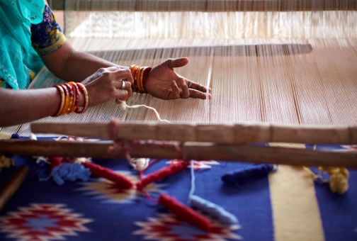 Indian woman weaving by hand on a loom