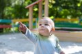 Toddler pointing while standing in playground
