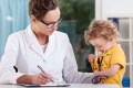 Doctor writing notes about child
