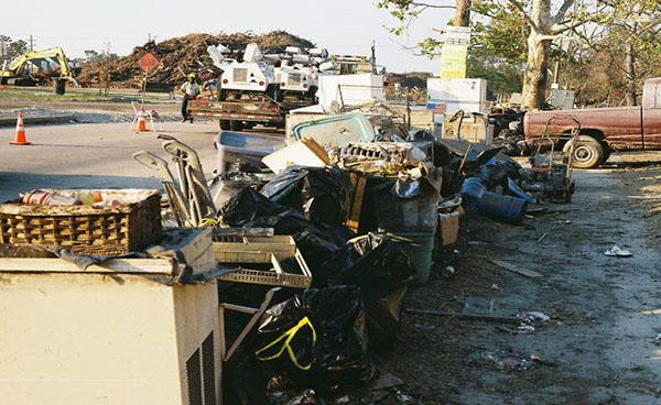 "Contents of our home piled up in the front yard. Piles of such debris were segregated by hazardous contents, and collected in the medians daily by the Army Corps of Engineers, the National Guard, and FEMA."
