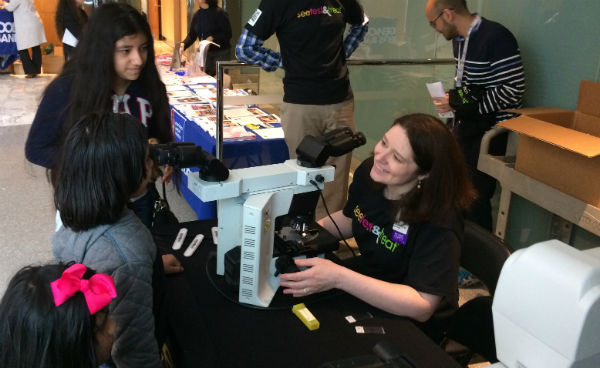 Children looking at microscope at See, Test & Treat event at Montefiore 