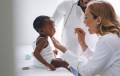 African American baby being prompted to say "ah" by doctor